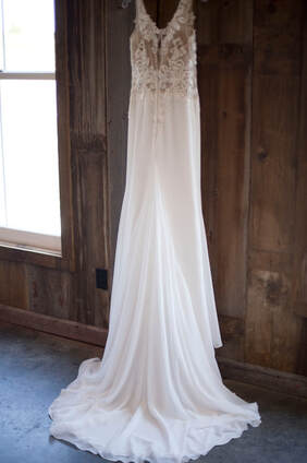 The back of a wedding dress hanging against a wall